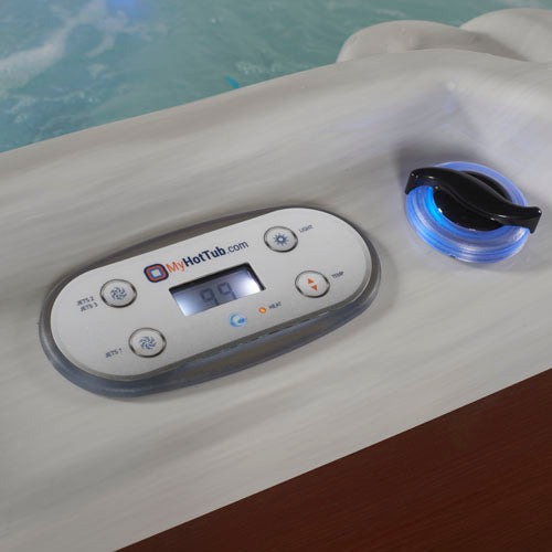 A close-up of a MyHotTub.com spa control panel and blue LED light, with turquoise water in the background.