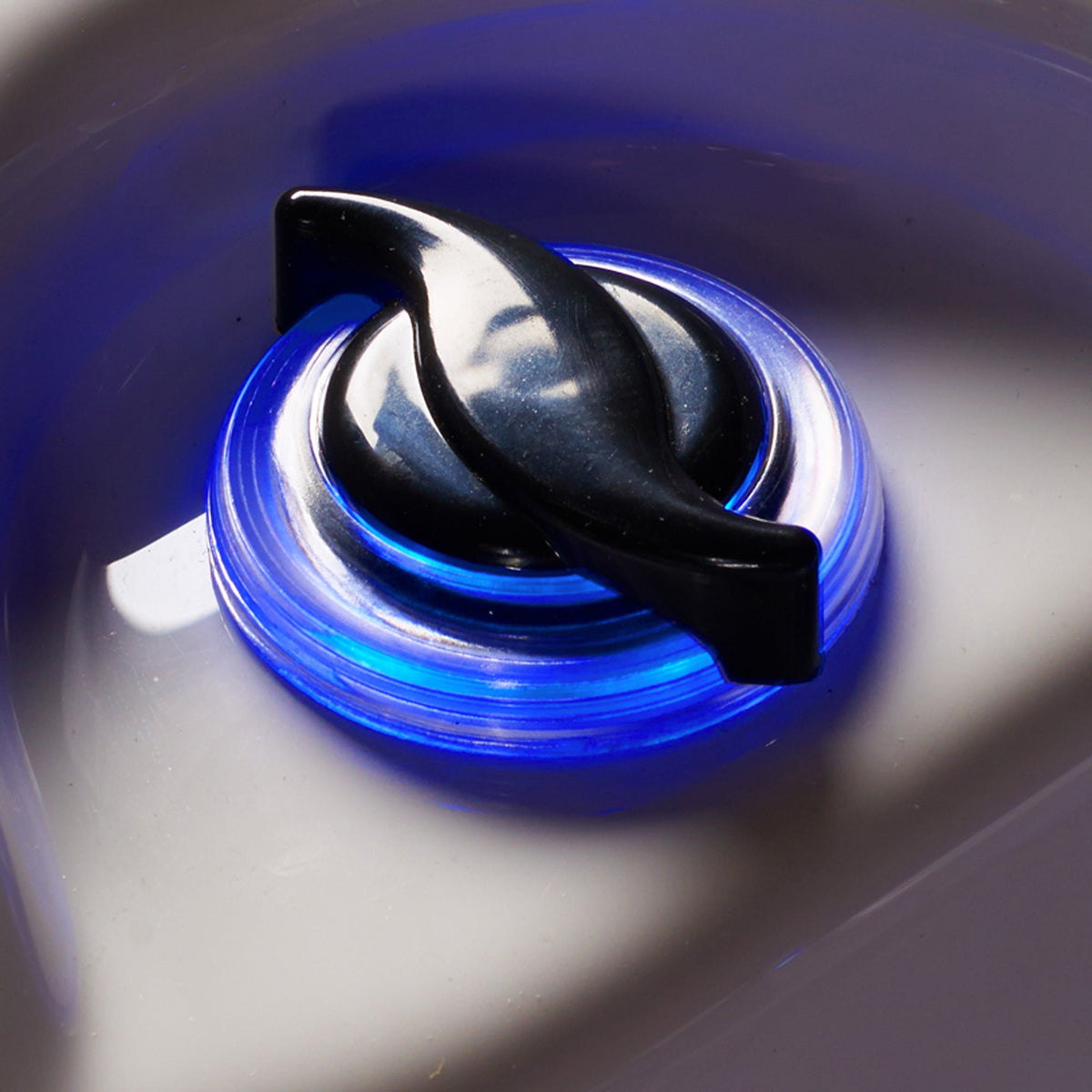 Close-up of a knob with blue light on an acrylic surface