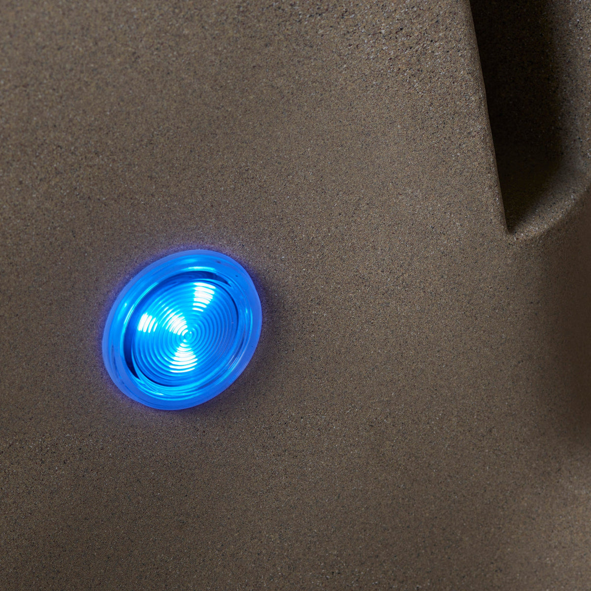blue glowing LED light on tan resin surface