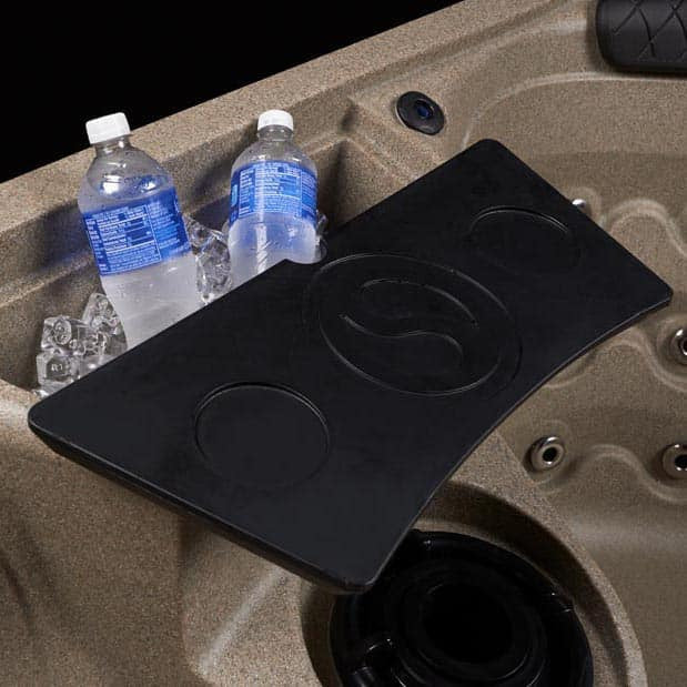 Black tray with cup holders on a beige vehicle seat, with water bottles and ice cubes.