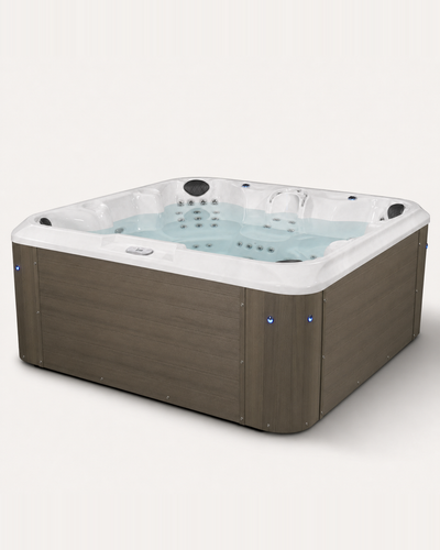 A square hot tub with a brown wood-look exterior and a white interior, filled with light blue water. The hot tub features multiple jet nozzles, a built-in waterfall feature, and blue LED accent lights on the front corners, set against a plain off-white background.