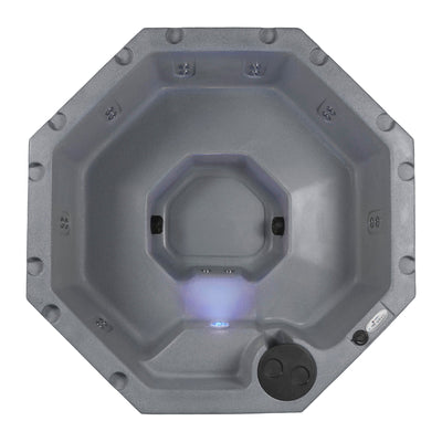 An octagonal hot tub viewed from directly above, featuring a textured gray exterior and interior, with stainless steel jets and a glowing blue LED light in the center on white background #color_gray