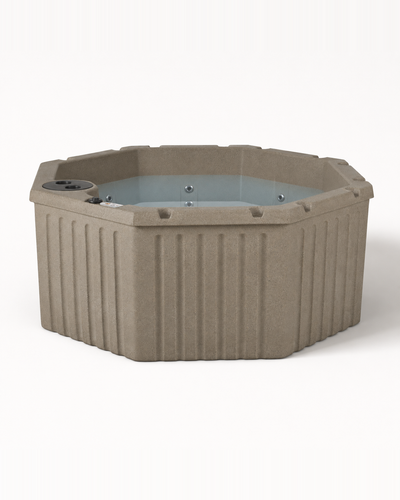 An octagonal hot tub in a textured taupe-gray finish, featuring a ribbed exterior wall and a light blue-tinted water pool, shown against a plain white background. #color_cobblestone
