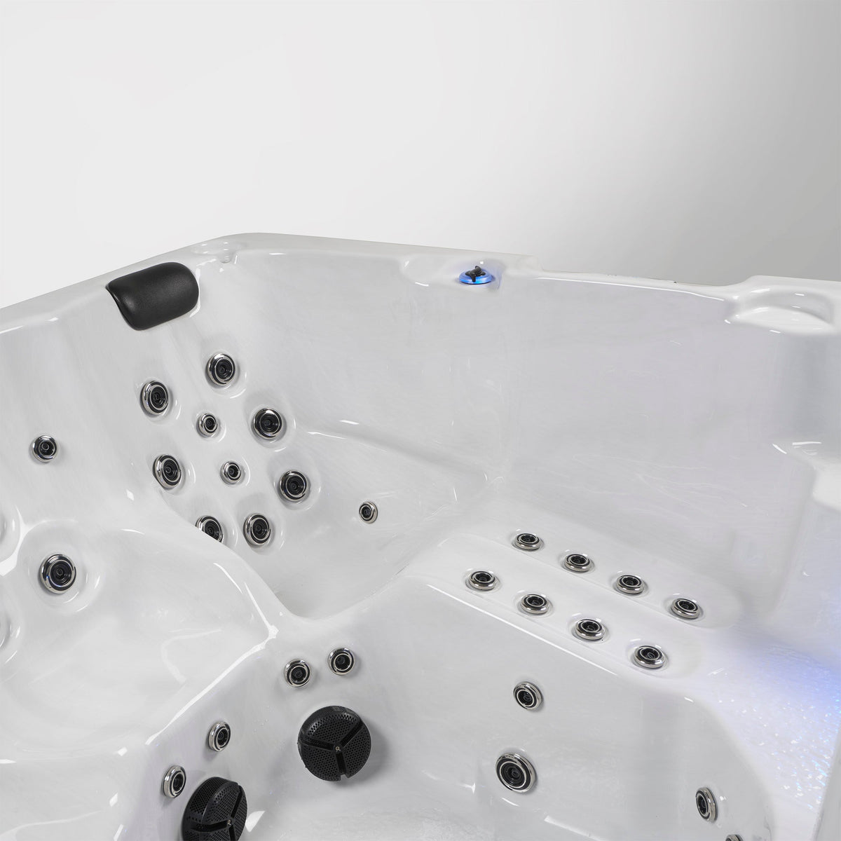 White hot tub interior with multiple jets and control knobs, photographed against a plain light background.