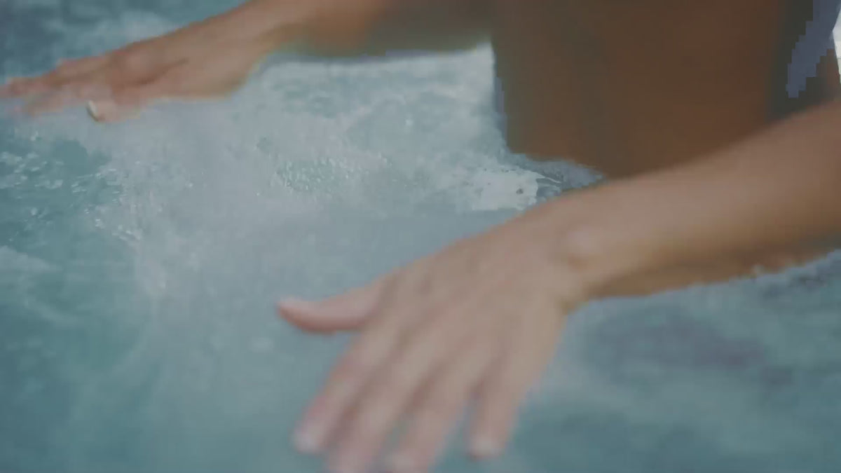 Load video: hands moving slowly in blue and white bubbly water 